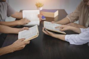 un groupe de chrétiens asiatiques est assis à l'intérieur d'une église catholique priant pour la bénédiction de dieu, le soleil pâle brillant dans le lieu de culte avec espace de copie. photo