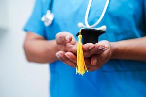 femme médecin asiatique tenant un chapeau de graduation à l'hôpital, concept d'éducation médicale. photo