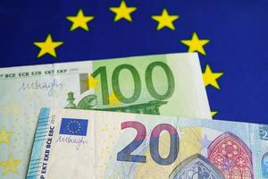 billets en euros argent sur le drapeau de l'ue, commerce économique en europe concept. photo