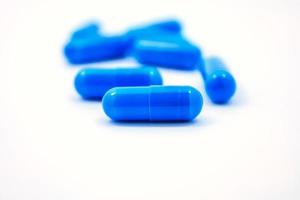 capsules bleues sur fond blanc photo