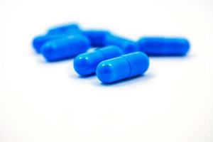 capsules bleues sur fond blanc photo