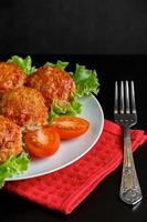 boulettes de viande appétissantes à la sauce tomate sur fond sombre. plat riche en protéines. photo