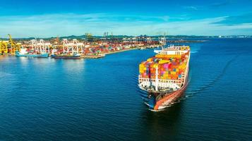 vue latérale aérienne d'un cargo transportant un conteneur et courant pour l'exportation de marchandises du port de fret au transport de technologie de concept océanique personnalisé, dédouanement. photo