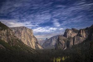 Vallée de Yosemite vue depuis le tunnel lors d'une nuit de pleine lune avec des nuages qui passent, Californie, États-Unis photo