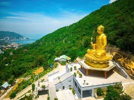 vue ariel la main de la statue de bouddha doré tenant le lotus au monastère de chon khong qui attire les touristes à visiter spirituellement le week-end à vung tau, au vietnam. notion de voyage. photo