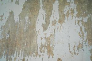 texture du vieux mur de béton gris pour le fond. texture rugueuse sur le mur gris forme rugueuse due à l'écaillage de la couche de peinture due à la pluie