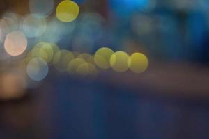 le bokeh de la ville de nuit brille sur fond clair vide. bannière aux chandelles brille résumé de paillettes d'or jaune. célébration de fond de conception photo