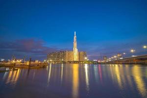 ho chi minh ville, vietnam, 11 février 2022 vue du coucher de soleil au point de repère 81 - c'est un gratte-ciel super grand et un pont de saigon avec des bâtiments de développement le long de la rivière saigon lisser la lumière photo