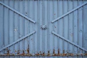 vieilles portes rouillées en fer, couvertes de peinture et de débris, photo frontale. texture de porte en métal gris de l'ère soviétique.