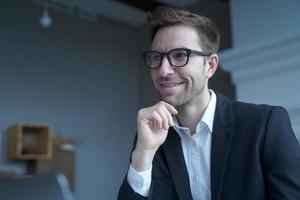 bel homme d'affaires autrichien positif portant des lunettes travaillant à distance depuis la maison photo