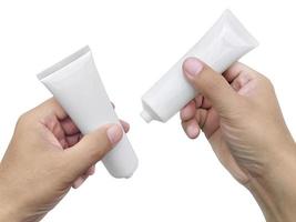 main tenant un tube en plastique cosmétique isolé sur fond blanc photo