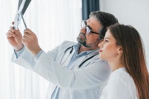 regardant la radiographie. des professionnels de la santé en blouse blanche sont au bureau photo