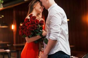 de belles roses. un couple romantique dîne au restaurant photo