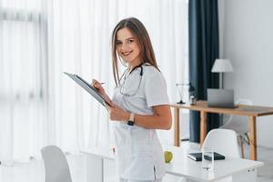 la femme est avec le bloc-notes. travailleur médical professionnel en blouse blanche est au bureau photo