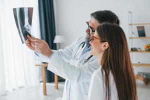 regardant la radiographie. des professionnels de la santé en blouse blanche sont au bureau photo