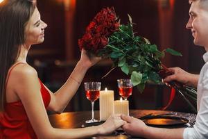 assis près de la table. un couple romantique dîne au restaurant photo