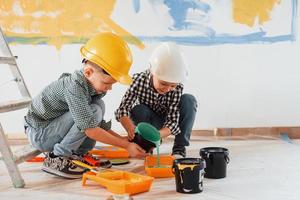 travaux en cours. deux garçons peignant des murs dans la chambre domestique photo