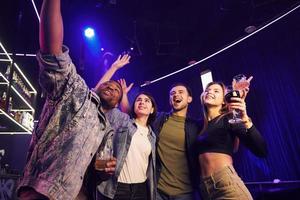 faire des selfies. groupe d'amis s'amusant ensemble dans la boîte de nuit photo