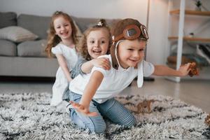 le garçon porte des lunettes d'aviateur. groupe d'enfants est ensemble à la maison pendant la journée photo