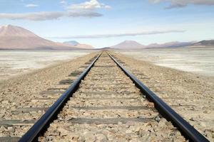 voies ferrées menant à l'horizon dans le salar de uyuni, bolivie