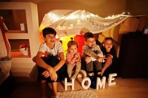 les enfants dans la tente regardent la télévision la nuit à la maison. humeur hygge. photo