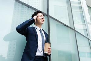 image de jeune homme d'affaires asiatique avec fond de bâtiment en verre photo