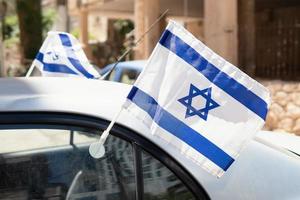 agitant au vent des drapeaux israéliens attachés à la fenêtre de la voiture. photo