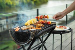 délicieuse viande grillée avec fumée, barbecue avec légumes en plein air. barbecue, fête, style de vie et concept de pique-nique photo