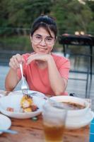 femme heureuse en train de dîner avec de délicieuses viandes grillées et un barbecue en plein air. barbecue, fête, style de vie et concept de pique-nique photo