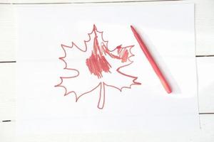 concept de la fête du canada. feuille d'érable rouge han dessinée par un enfant. photo