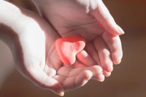 mains tenant un coeur rouge, soins de santé, amour, journée nationale du don d'organes photo