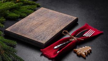 une planche à découper en bois vide avec des couverts en bois sur une table de cuisine de noël photo