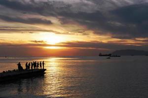 silhouettes de pêcheurs sur fond de coucher de soleil. photo