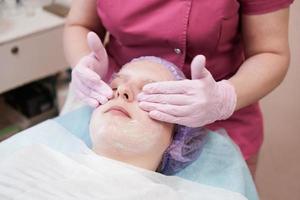 adolescente recevant des soins du visage par une esthéticienne au salon de spa photo