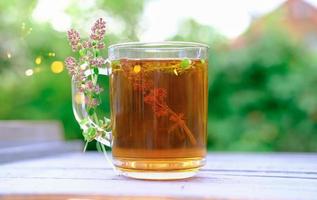 thé au thym dans une tasse en verre. tisane pour la santé. photo