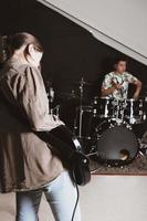 répétition du groupe de rock dans un studio. guitariste basse et batteur masculin adolescent interprétant une chanson. taille verticale photo