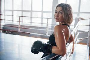 grand ring de boxe. sportive féminine. dans des vêtements de couleur noire photo