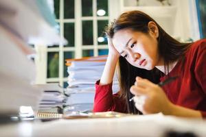 une femme stressée a mal à la tête pendant les rapports de contrôle pendant les heures supplémentaires à la maison photo