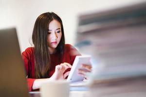 comptable asiatique à l'aide d'une calculatrice pendant les heures supplémentaires la nuit. les bourreaux de travail photo