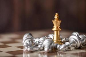 roi d'or debout au milieu des échecs qui tombent à bord photo