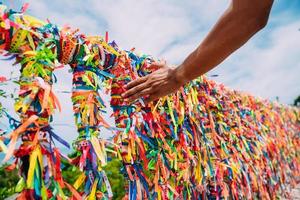 gros plan de rubans colorés à arraial d'ajuda, bahia, brésil. main d'homme faisant une commande avec des rubans brésiliens photo