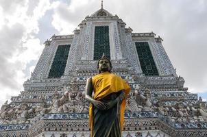 bouddha avec fond de construction de temple au wat arun ratchawararam ratchaworamahawiharn, bangkok, thaïlande photo