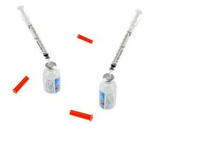 seringue et bouteille d'insuline isolées sur fond blanc. la photo est focalisée sur la zone de l'aiguille.
