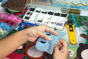 une femme fait des travaux d'aiguille avec d'autres équipements de broderie sur une table photo