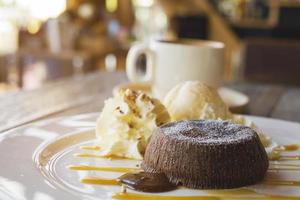 gâteau de lave au chocolat dans une assiette blanche avec une tasse de café dans un café photo