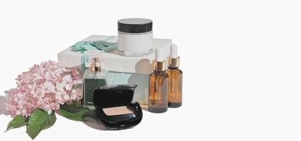 cadeau de beauté pour femme. produits cosmétiques sur fond blanc, isolés. cosmétique décorative et de traitement avec coffret cadeau et fleurs. espace de copie. photo