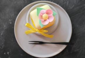 vue de dessus d'un mini gâteau décoré de feuilles de fleurs comestibles en papier de riz. friandise sucrée pour la sélébration d'halloween d'automne, décor de ruban. couverture de glace. photo