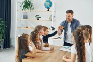 avec casse-tête. groupe d'enfants élèves en classe à l'école avec professeur photo