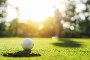 joueur de golf mettant une balle de golf dans un trou photo