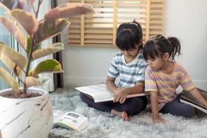 frères et sœurs concentrés lisant un livre photo